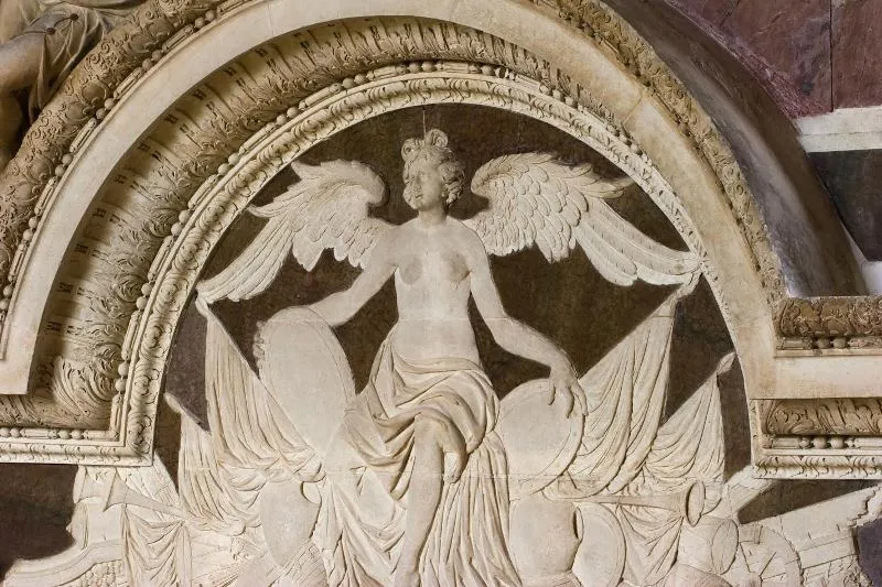 Stone carved relief depicting a winged angel with flowing drapery in an ornate arched niche at the Ducal Castle of Cadillac in Bordeaux