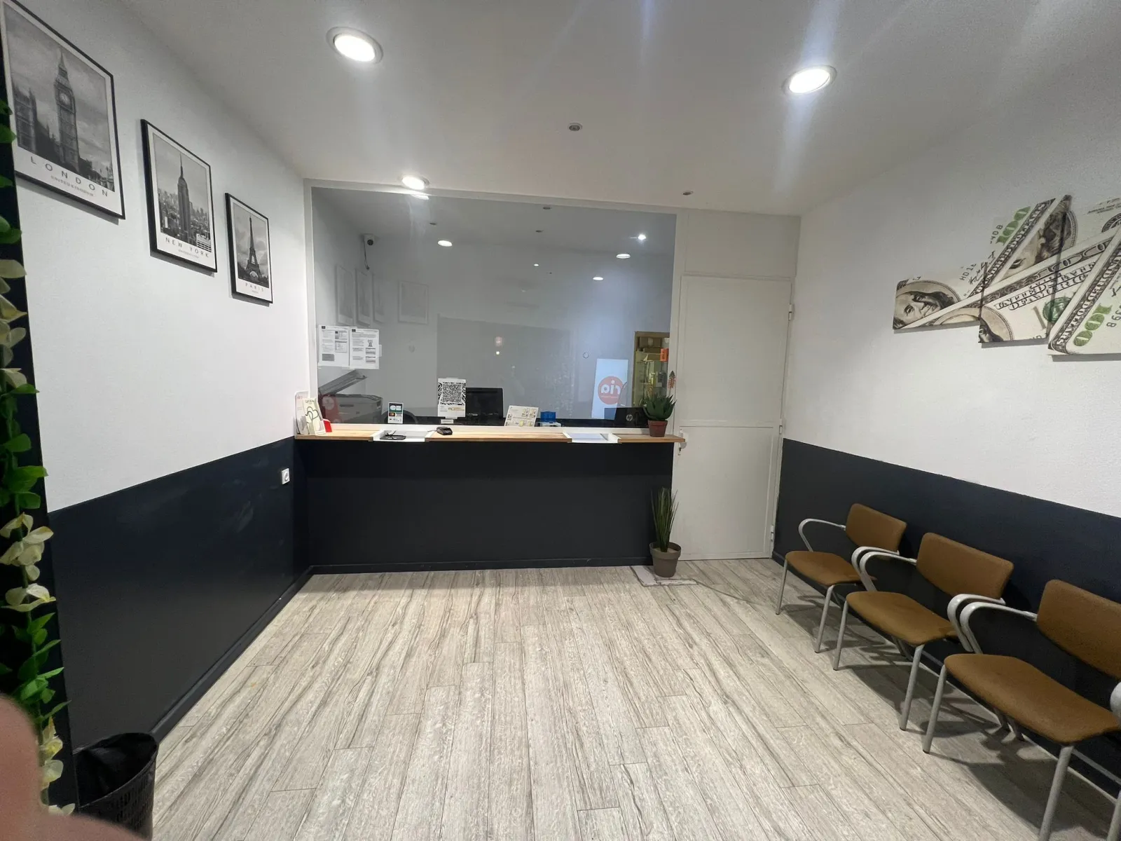 Interior of Monex Exchange office in Bordeaux Gambetta featuring a reception counter, brown waiting chairs, modern wall decor, and light wooden flooring