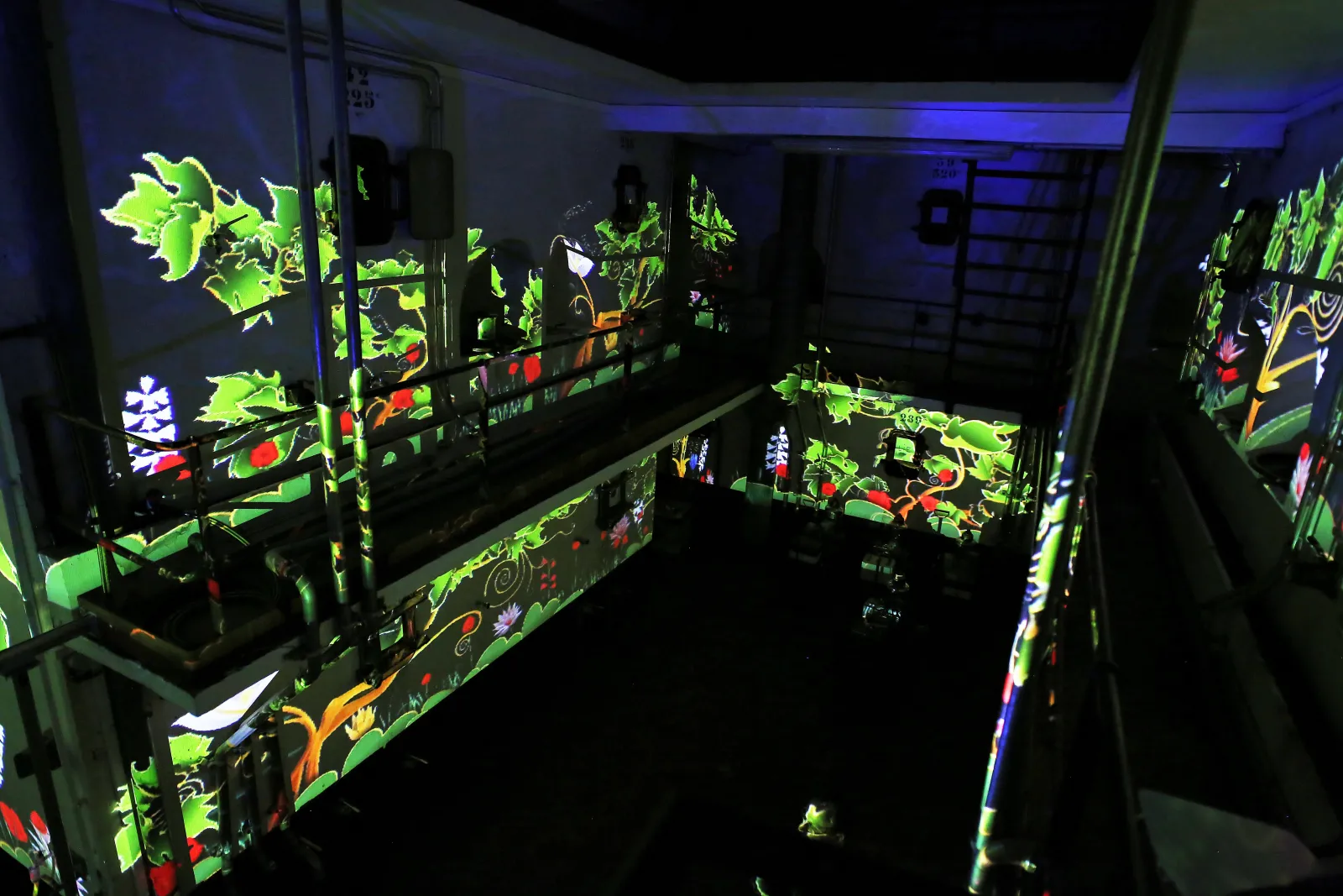 Fluorescent display cases featuring stylized tropical plants in bright neon green and vibrant colors in a Bordeaux wine cellar