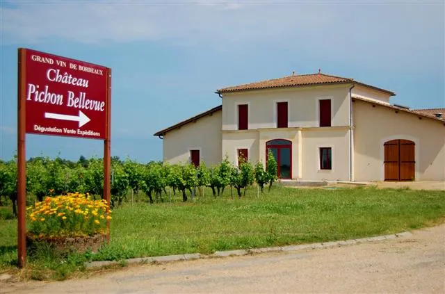 Entrance sign of Château Pichon Bellevue with the main building in the background, located in Bordeaux vineyards