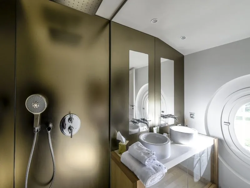 Modern bathroom at Château Beauregard in Bordeaux featuring walk-in shower, white sink, mirrors and luxury amenities