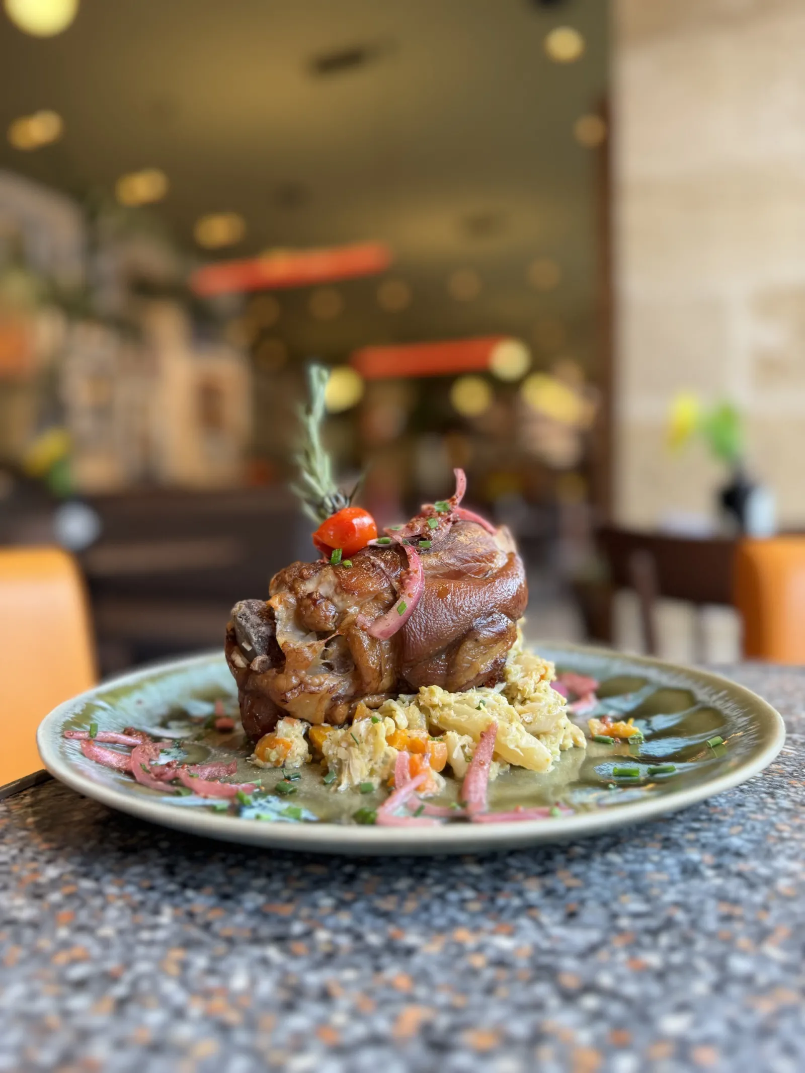 Roasted meat dish with potato salad and tomato garnish served at Cajou Caffé restaurant in Bordeaux
