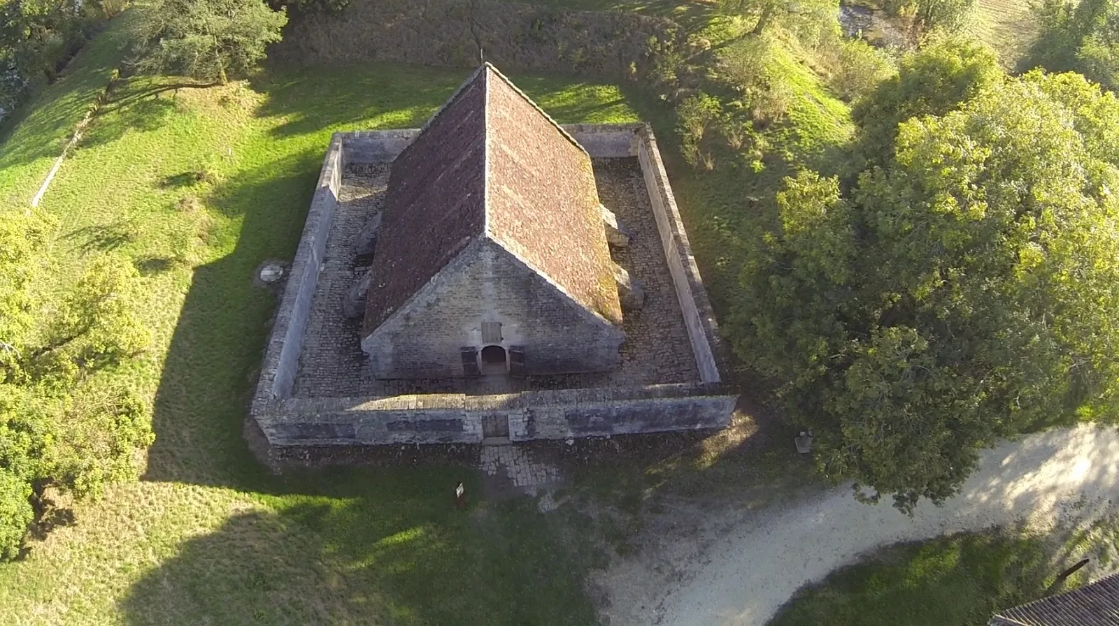 Aerial view of Fort Médoc near Bordeaux, a brick fortress with pitched roof surrounded by moats and green vegetation