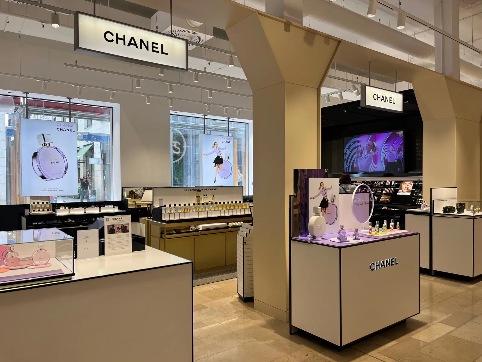 Chanel boutique at Galeries Lafayette in Bordeaux displaying fragrances and luxury products in a modern retail space with display windows, counters, and digital screens.