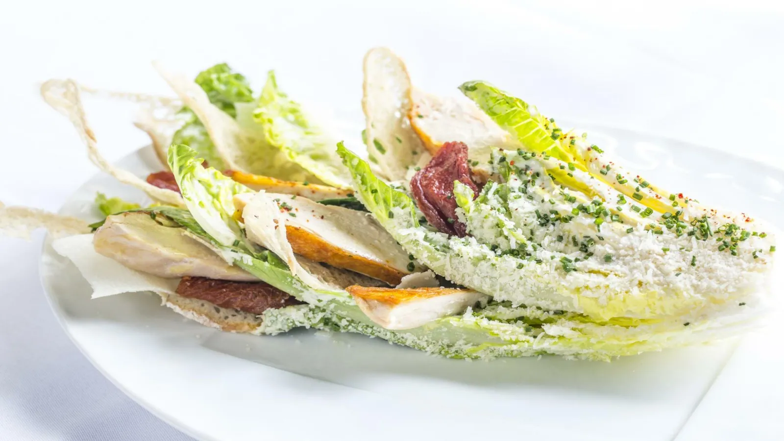Gourmet sandwich with fresh mozzarella, beetroot, endives and aromatic herbs on seeded bread, served on white plate