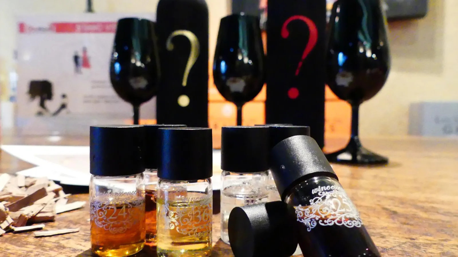 Wine tasting at Château Pas de l'Âne in Bordeaux featuring glasses of red wine and numbered bottles in the background