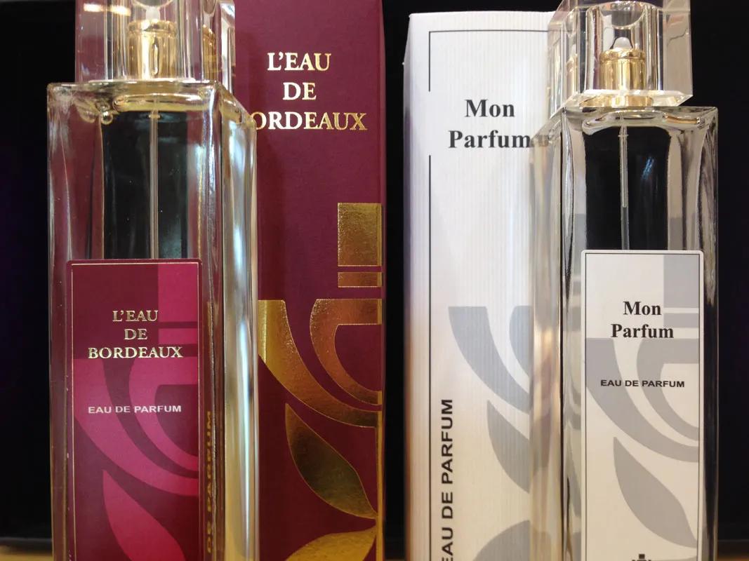 Four perfume bottles from the Parfumerie de l'Opéra in Bordeaux, including two « L'eau de Bordeaux » bottles with red packaging and two « Mon Parfum » bottles with white packaging.