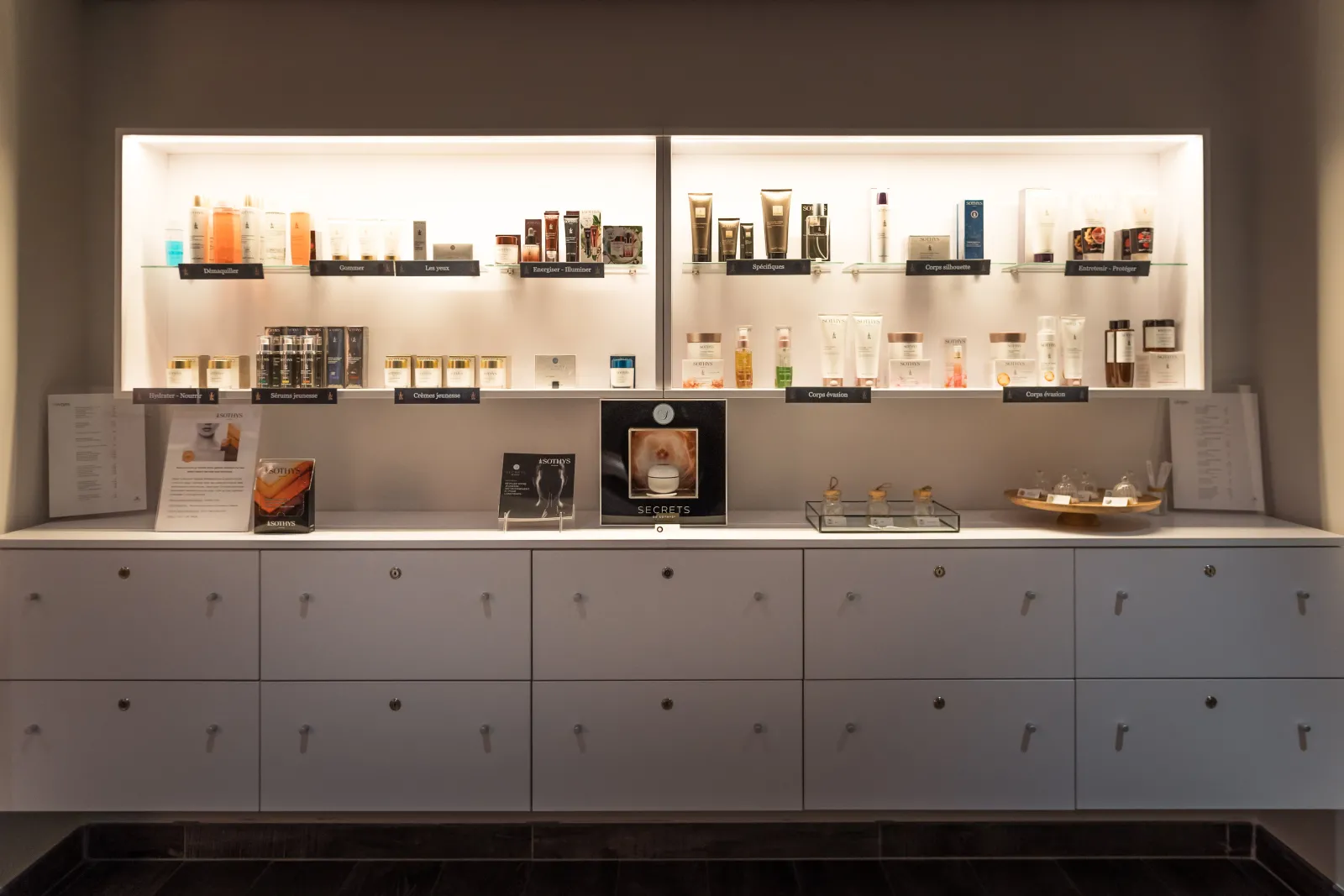 Display of luxury beauty and skincare products in the Radisson Blu Hotel Bordeaux, featuring illuminated shelves with premium cosmetics and grooming items.