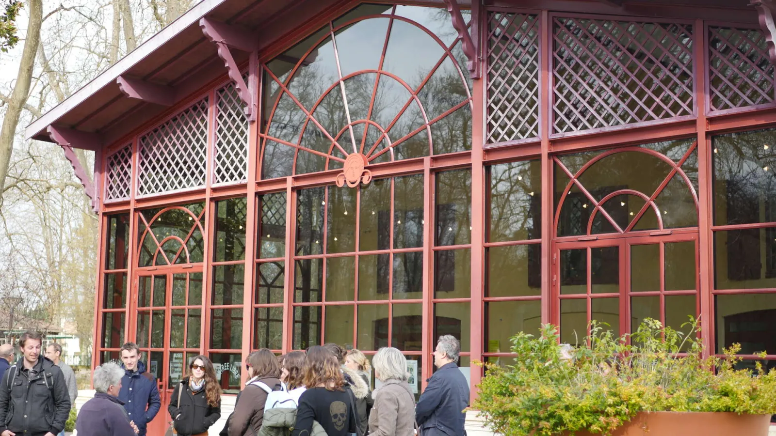 Front facade of the Georges de Sonneville Museum in Bordeaux featuring large paned windows and a glass roof in Art Nouveau style, with visitors gathered at the entrance