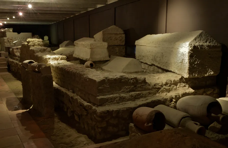 Archaeological remains from the Saint-Seurin site in Bordeaux, displaying stone foundations, sarcophagi, and ceramic fragments from Roman and medieval periods.