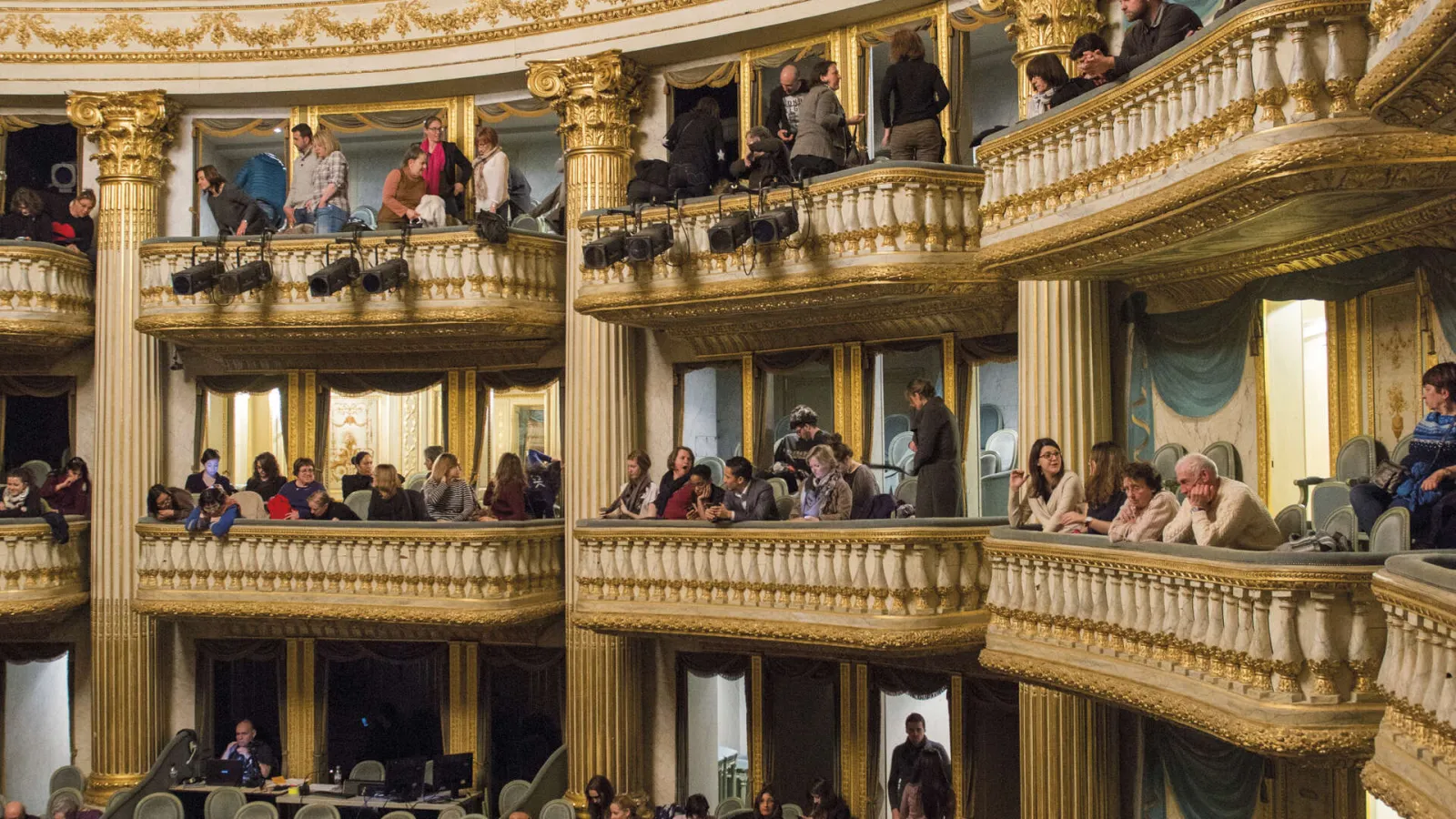 Interior of the Grand Theatre of Bordeaux with spectators in gilded and ornate boxes across multiple levels.