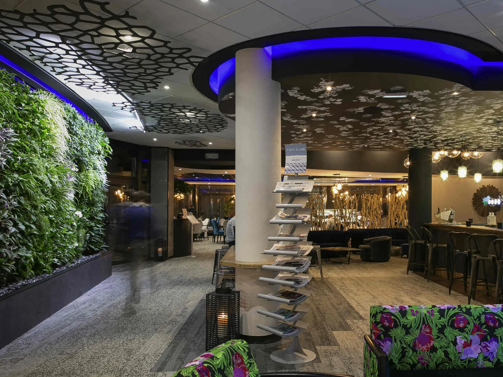 Modern interior of Spirit in Bordeaux featuring illuminated living wall, blue geometric ceiling, white columns and contemporary designer furniture