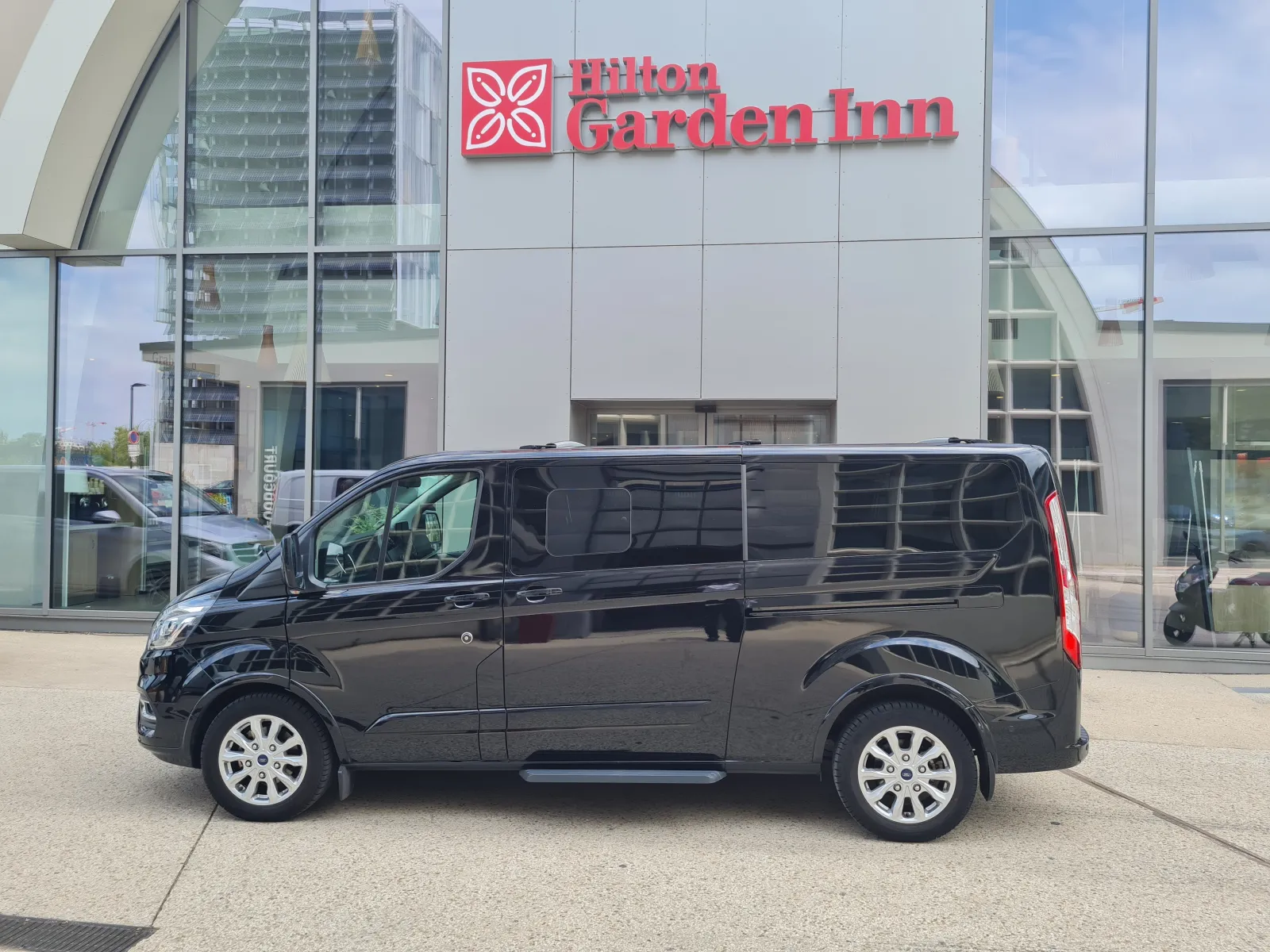 Black minivan parked in front of Hilton Garden Inn hotel in Bordeaux, VTC service