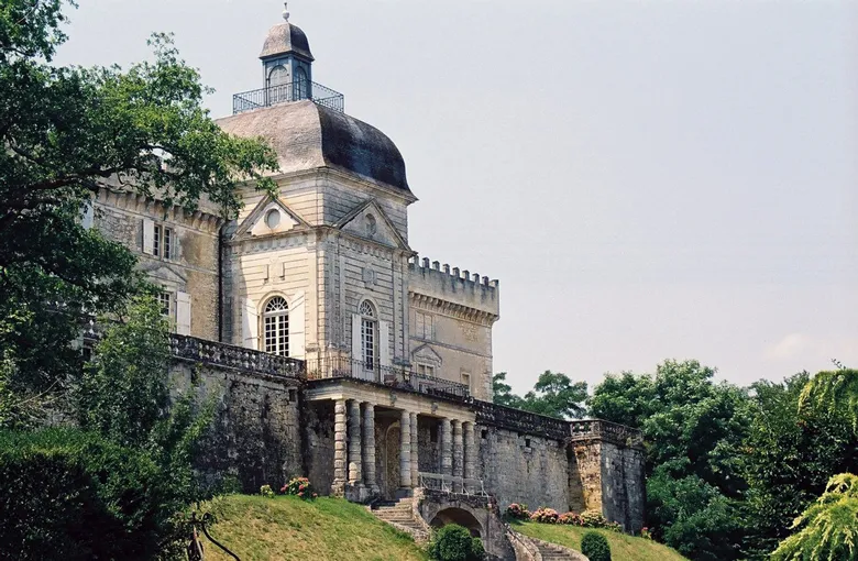 Château de Vayres near Bordeaux, a medieval fortress featuring a mansard dome, surrounded by stone walls and lush greenery.