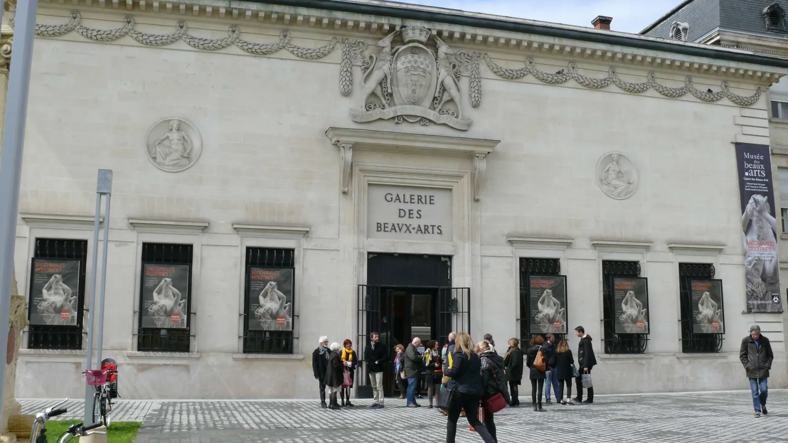 Facade of the Bordeaux Museum of Fine Arts, neoclassical white building with columns and sculptural medallions, main entrance with visitors outside
