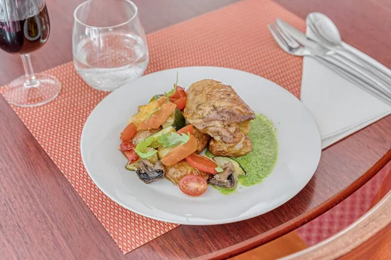 Grilled meat plate with roasted vegetables and green sauce, served at le Soretel restaurant in Bordeaux Mérignac