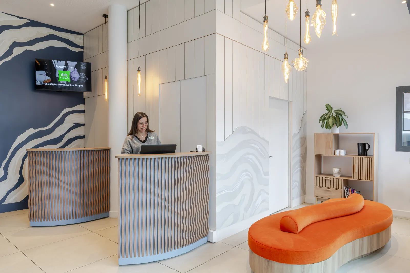 Modern reception area of Ibis Styles Bordeaux Lac Bruges hotel featuring check-in desk, contemporary furniture and stylish décor