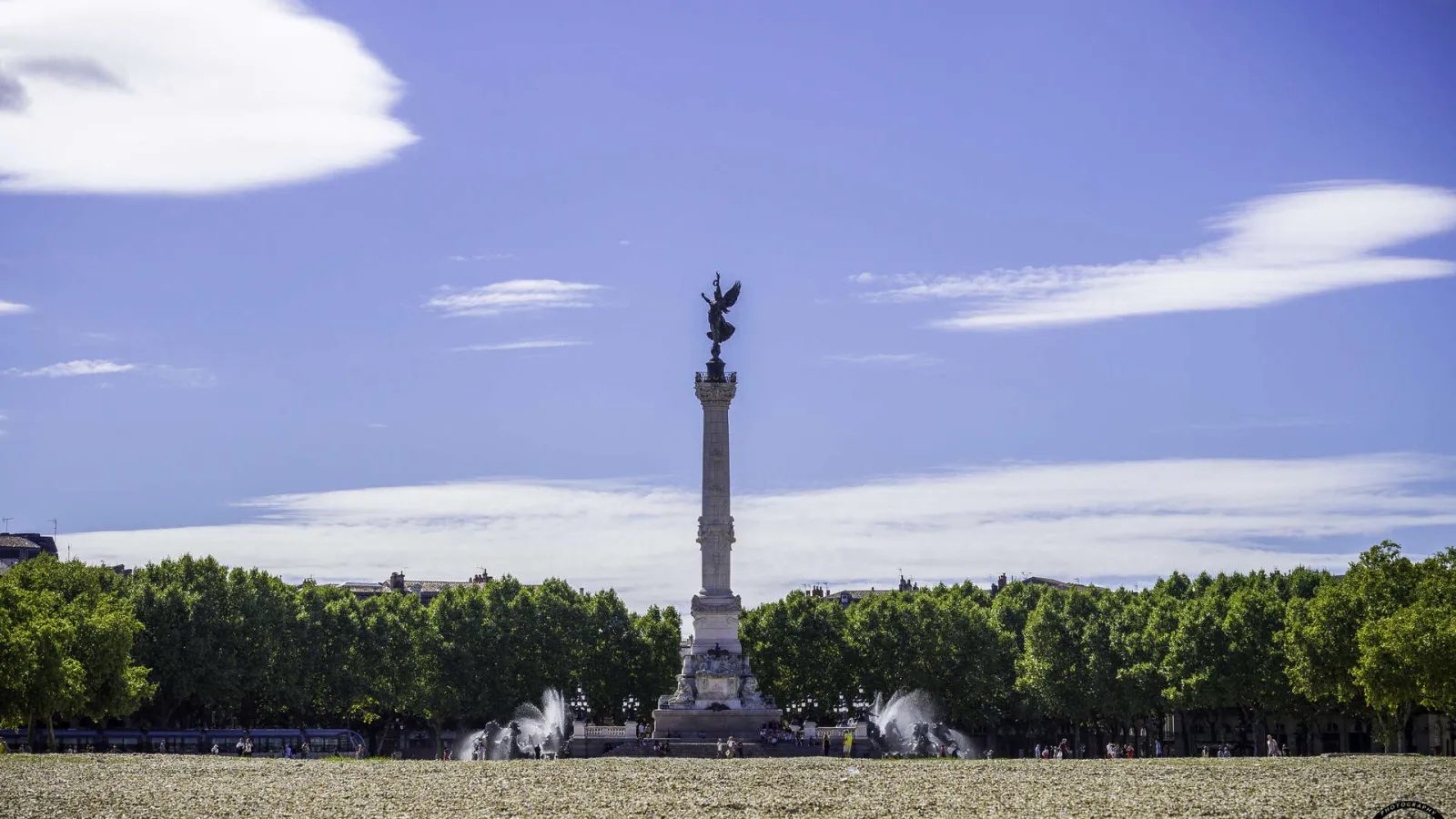 Monument to the Girondins on the Esplanade des Quinconces in Bordeaux, featuring a central column topped with a golden statue, surrounded by trees and fountains