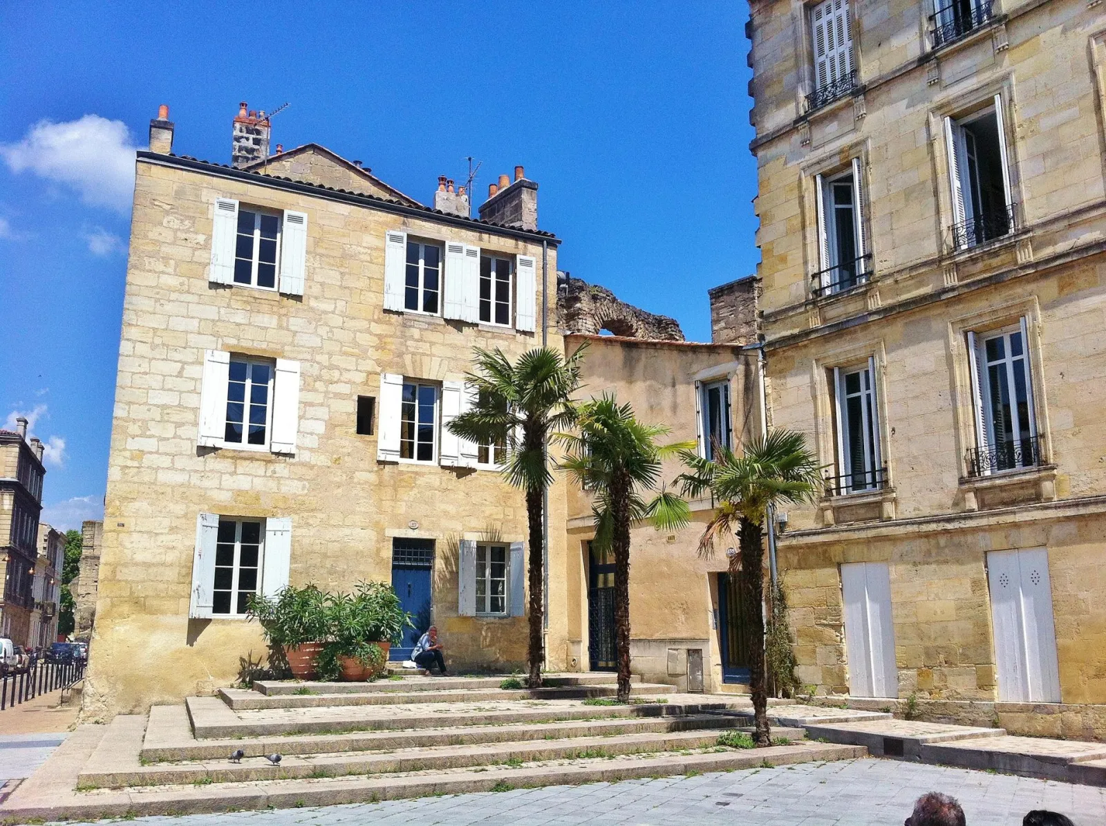 Inner courtyard surrounded by stone-built period buildings with palm trees in Bordeaux