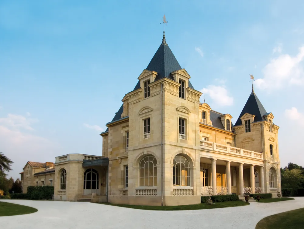 Château Léognan in Bordeaux, an elegant Second Empire mansion with limestone facade, pointed towers with black slate roofs and ornamental balustrades