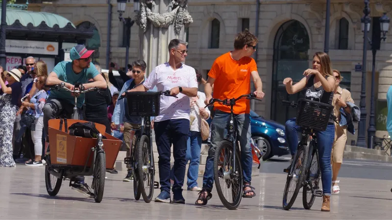 Group of cyclists on a guided bike tour in front of a historic building in Bordeaux, with spectators watching the event.