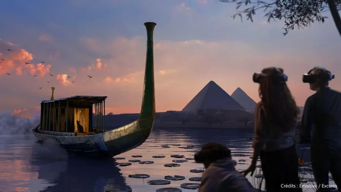 Immersive exhibition view featuring a stylized Egyptian boat on water, pyramids in the background, and visitors watching the scene at sunset.