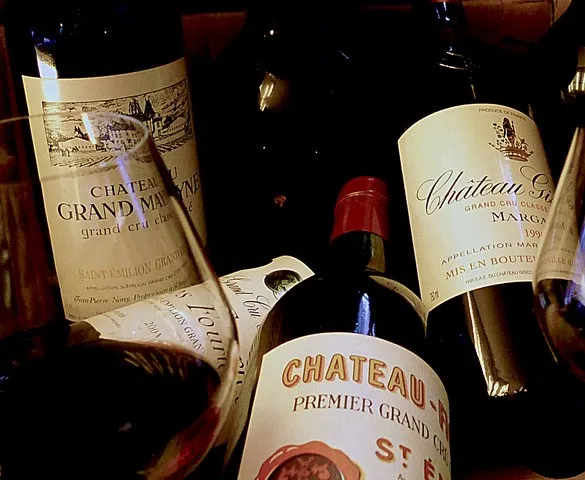 Collection of Bordeaux wine bottles including Château Grand-Mayne and Château Margaux, prestigious wines with grand cru labels.