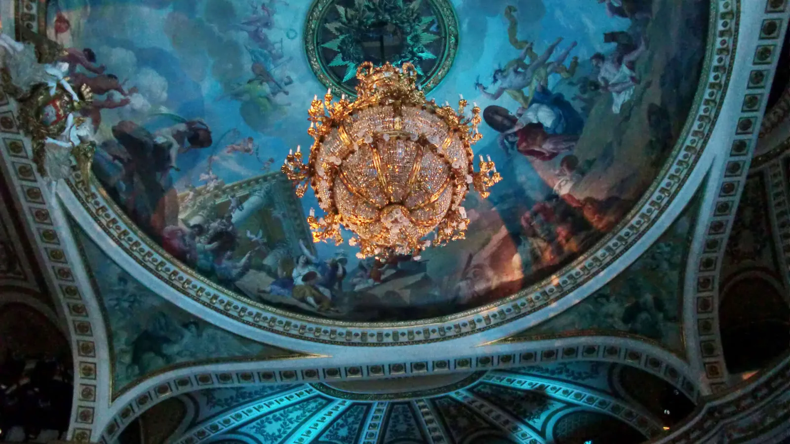 Ceiling of the Grand Theatre of Bordeaux featuring a blue fresco with allegorical figures and an ornate golden chandelier in the center