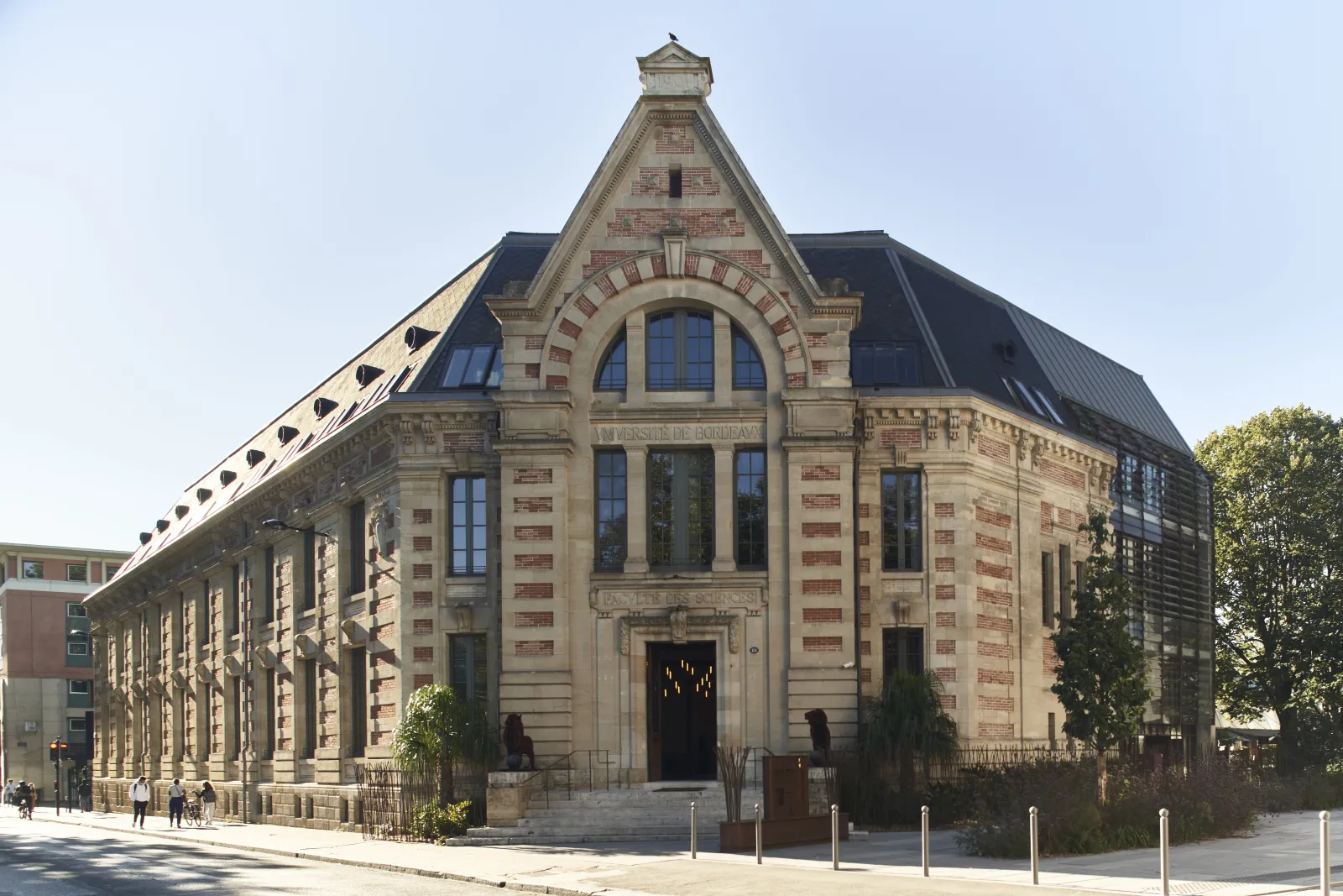 Facade of the Hôtel La Zoologie in Bordeaux, a historic stone building with mansard roof, large arched windows, and architectural details in red brick and light stone.