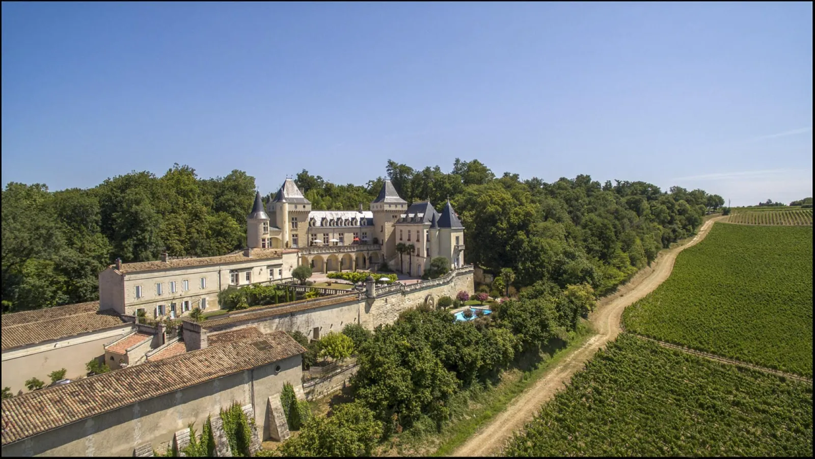 Château de La Rivière near Bordeaux, a stately castle with turrets and stone façade, surrounded by lush vineyards and forests.