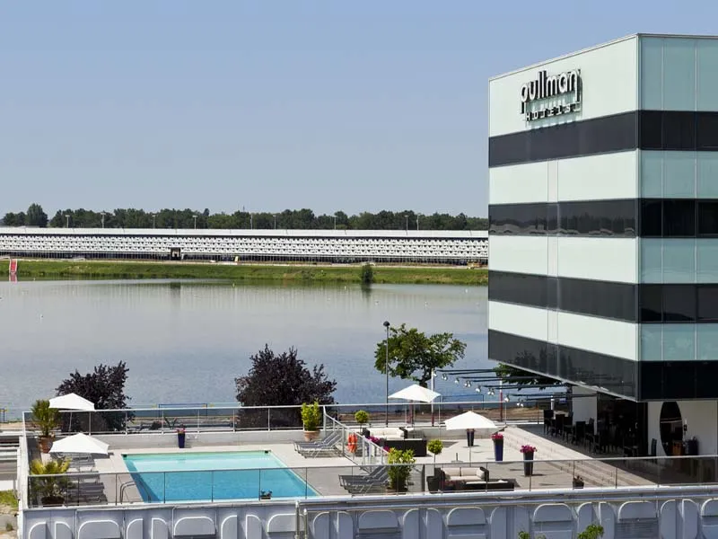 Pullman Bordeaux Lac hotel featuring striped modern architecture overlooking a water basin with outdoor swimming pool and terrace