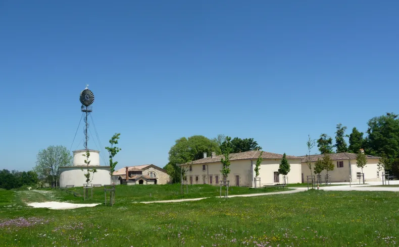 Beauval Estate near Bordeaux featuring a Bollée windmill, stone buildings and a green park under clear blue sky