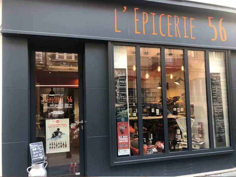 Storefront of L'Epicerie 56, a gourmet grocery store in Bordeaux, featuring display windows with products and promotional signage