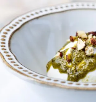 Elegant plate featuring pesto sauce and sliced almonds, presented on white porcelain with gold trim, fine dining dish from Chais de la Fleur in Bordeaux