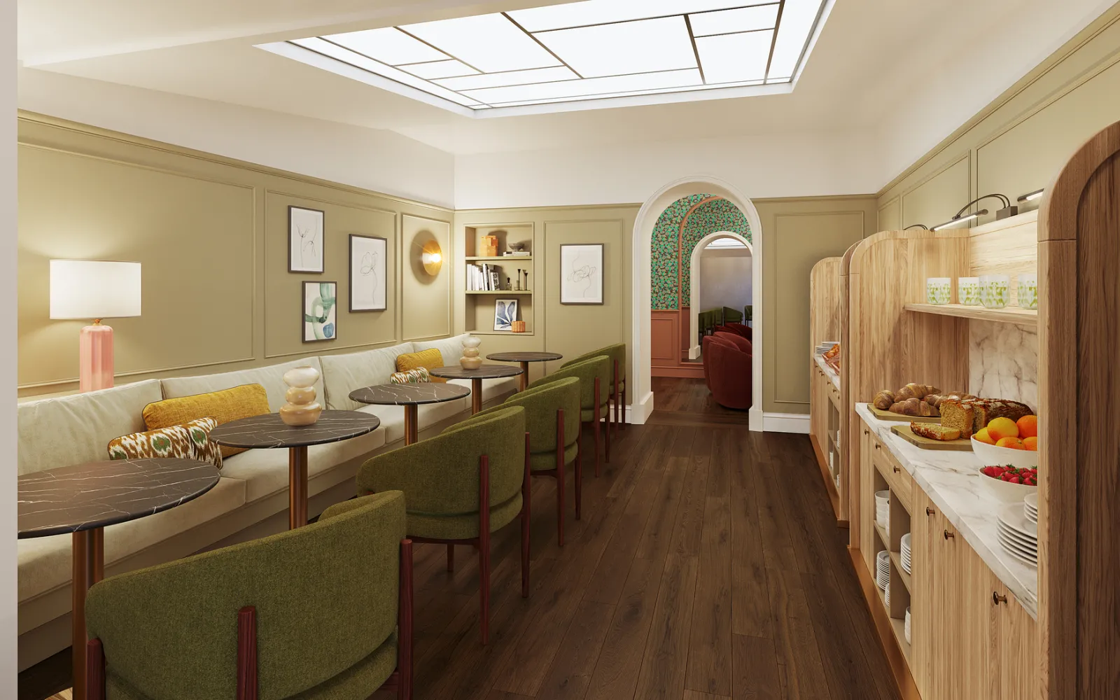 Elegant interior of a Bordeaux boutique hotel featuring pale yellow walls, green upholstered seating, dark wood tables and floor, wooden storage cabinets, illuminated ceiling, and an arched doorway to an adjacent room.