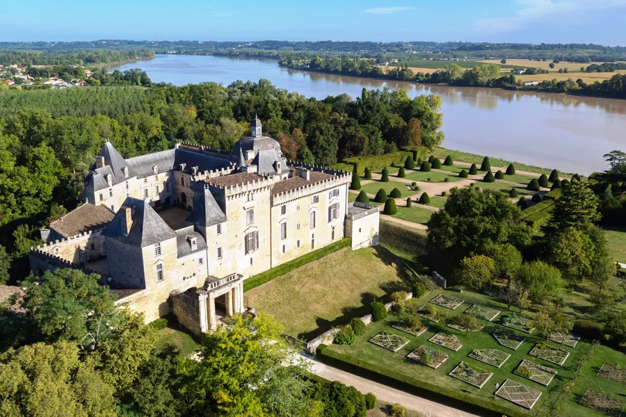 Aerial view of Château de Vayres near Bordeaux, medieval fortress with towers and ramparts, formal gardens on terraces overlooking the Dordogne river