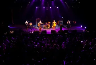Live concert at Rock School Barbey in Bordeaux with performers on stage under purple stage lighting and audience in the foreground