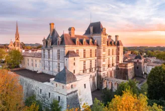 Aerial view of Cadillac Ducal Castle at sunset, a Renaissance fortress with slate roofs surrounded by fortifications, located near Bordeaux in Aquitaine.