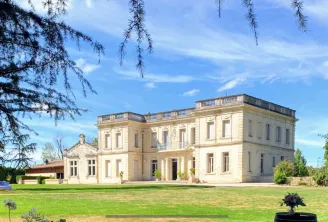 Château La Chèze in Bordeaux, a neoclassical stone mansion with symmetrical facade, situated in a lush green park surrounded by ancient trees