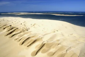 Aerial view of Dune du Pilat showing its distinctive rippled white sand patterns overlooking the Atlantic Ocean and Arcachon Basin
