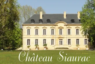Château Siaurac, a classical mansion with pale yellow facades and slate roof, surrounded by ancient trees and green lawns in Bordeaux.