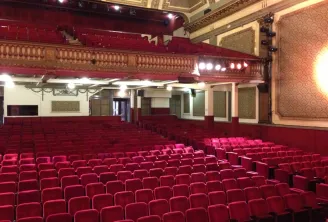 Interior of Bordeaux's Théâtre Fémina with red seats, ornate balcony and classical decor