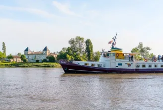 River cruise ship Marco Polo sailing on the Garonne in Bordeaux, with a historic castle visible on the left bank