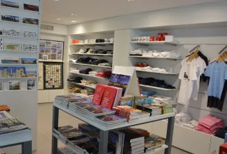 Bordeaux Tourism Office shop displaying souvenirs, travel guides, postcards, clothing and regional items on shelves and display tables.