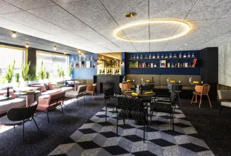 Modern reception area in Bordeaux featuring contemporary furniture, decorative shelving, innovative lighting, and city views