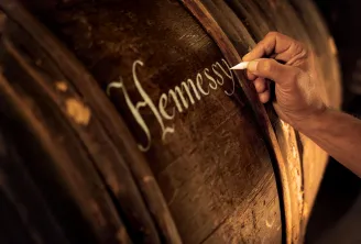 Hand engraving the Hennessy name on a cognac barrel at Hennessy House in Bordeaux