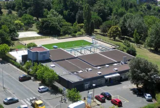 Aerial view of Lormont municipal swimming pool in Bordeaux featuring pools, facilities, parking lot and surrounding green areas