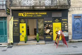 Storefront of Monex Exchange currency exchange bureau in Bordeaux on Gambetta street, featuring yellow and black signage offering exchange services, Western Union, and gold trading.