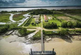 Aerial view of Île Nouvelle in Bordeaux showing a property with buildings, cultivated lands and a river landing stage, surrounded by waterways and marshlands.