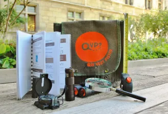 Treasure hunt kit 'Who wants to track Bordeaux' featuring backpack, notebook, compass, flashlight, measuring tape and exploration tools on a Bordeaux terrace
